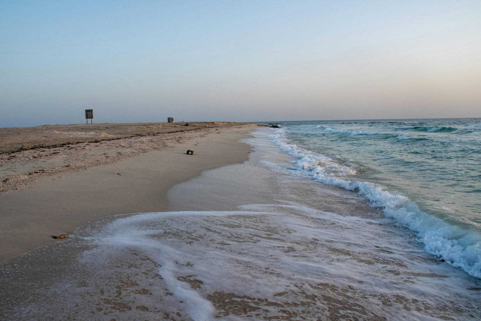 Serene beach with waves gently hitting the shore, perfect for relaxation.